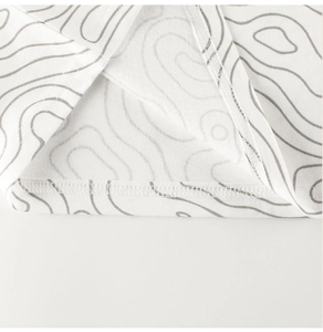 Close-up of fine double-needle stitching and grey wavy pattern on kids' cotton T-shirt