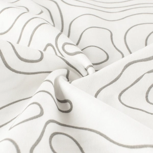 Macro view of white children's t-shirt fabric featuring grey topographic wave patterns