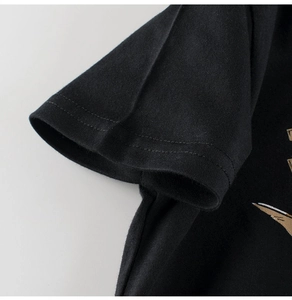 Detail of double-stitched sleeve cuff on a black cotton dinosaur t-shirt for boys