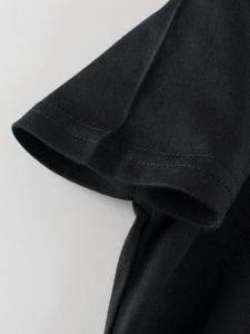 Detail of high-quality double-stitch seam on black cotton boy's dinosaur T-shirt sleeve