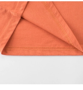 Close-up of the professional overlock stitching on the hem of this orange cotton t-shirt