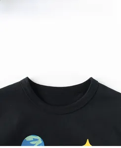Close-up of ribbed crew neck and starry space print on black cotton kids T-shirt
