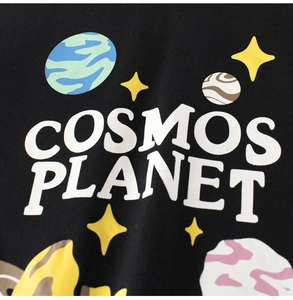 Detail of Cosmos Planet graphic print on black cotton kids t-shirt with starry patterns