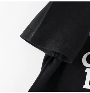 Macro detail of high-density cotton black t-shirt showing sleeve stitching and white print