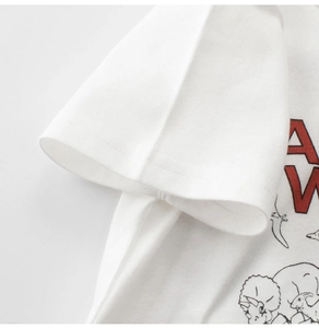 Detail of sleeve stitching and cartoon dinosaur print on white cotton kids T-shirt