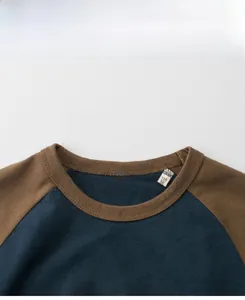 Detail of a boy's crew neck tee with raglan sleeves and size label in size 110/56