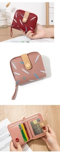 Détails des fentes pour cartes et de la poche zippée du portefeuille à motif plume
