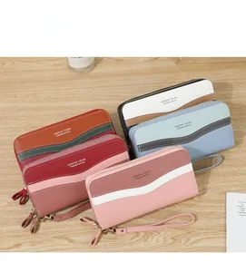 Detail of multi-color patchwork long wallets with lychee texture and wristlet straps