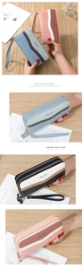 Detail of the dual zipper long wallet featuring a wave pattern and pebble leather texture