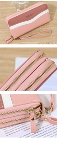 Detailed close-up of pink and white color-block long wallet with dual zippers and wristlet