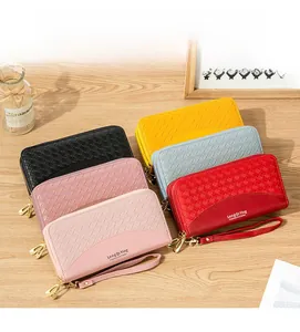 Selezione di cinque portafogli lunghi intrecciati in vari colori su un tavolo in legno