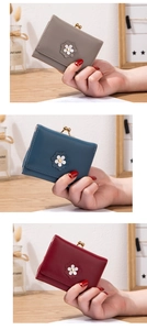 Gros plan du portefeuille à trois volets avec fermoir kiss-lock et fleur en cuir