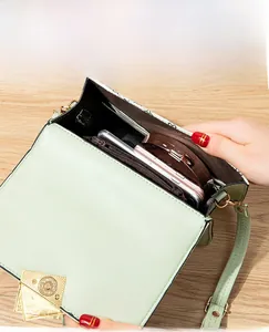 Detail view of the mint green crossbody bag interior showing organized compartments for phones