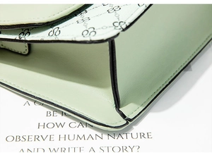 Close-up of mint green leather bag showing edge finishing and geometric logo pattern