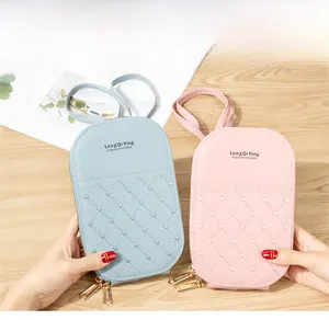 Detail of heart-quilted cross-body phone bags with double zippers in pink and blue colors