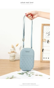 Detail of light blue mobile phone bag featuring diamond lattice stitching and heart patterns