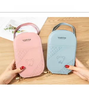 Close-up of pink and blue mini crossbody bags with cute bear pattern and gold zippers