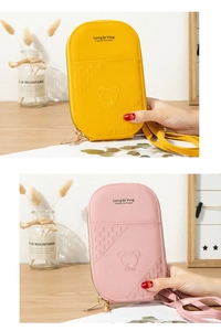 Detail of yellow and pink mobile phone bags with bear embroidery and woven texture