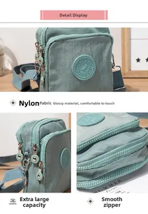 Detail of light green multi-pocket nylon crossbody bag with smooth zippers and metal hardware