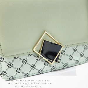 Light green faux leather crossbody bag with S-pattern print and gold geometric buckle