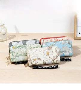 Detail of long floral wallets with double zippers and LOVE lettered straps in four colors
