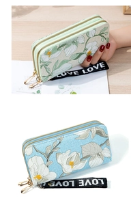 Detail of light green and blue long wallets with floral embroidery and wrist straps