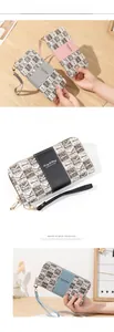 Détail d'un long portefeuille zippé pour femme avec toile monogramme et dragonne amovible