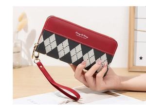 Détail d'un long portefeuille en cuir PU avec motif losanges gris et cuir rouge