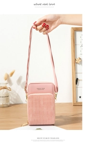 Close-up of pink PU leather crossbody bag featuring crocodile texture and gold zipper detail