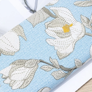 Light blue fabric wallet with elegant white magnolia floral embroidery and double zippers