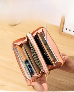 Portefeuille rose à double fermeture éclair montrant l'intérieur pour cartes et mobile