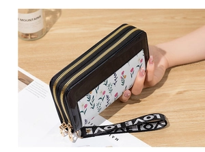 Detail of black double zipper wallet with floral panel and LOVE woven strap