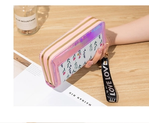 Floral double zipper long wallet with laser pink trim and 'LOVE' wrist strap on wood desk