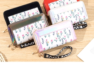 Detail view of multi-color long wallets with floral patterns and LOVE wrist straps