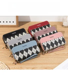 Detail view of colorful quilted long wallets with dual zippers and wrist straps on a desk