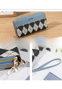 Detail view of double-zipper long wallet in blue faux leather with argyle pattern and wrist strap
