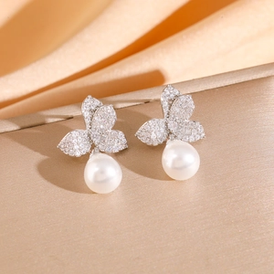 Detail of silver floral drop earrings with cubic zirconia and round white pearls