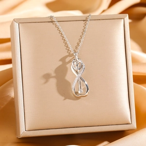 Collier pendentif cheval infini en argent avec zircons sur un coffret cadeau doré