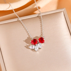 Collier de luxe avec pendentif rubis rouge en cœur et zircons sur fond de soie dorée