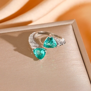 Macro view of crossover ring featuring two emerald triangles and micro-pavé accents