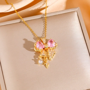 Collana dorata con cristalli a cuore rosa e ciondolo a stella su sfondo di seta