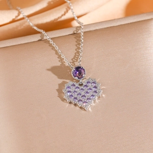 Silver-plated heart necklace with sparkling purple zircon stones on elegant satin fabric