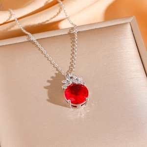 Elegant silver necklace set with a large round red ruby pendant and diamond accents