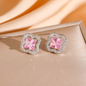 Detailed shot of silver clover earrings with pink square stones and zircon stones