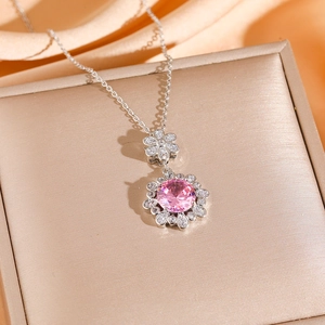 Pink zircon flower necklace and stud earrings set in silver finish on silk background