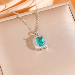 Elegante set con gemma verde taglio smeraldo e halo di zirconi su seta color champagne