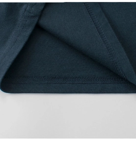 Detailed close-up of double-stitched hem on a dark teal cotton T-shirt for kids