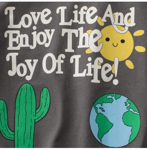 Close-up of kids t-shirt with sun and cactus print and Love Life text on dark grey fabric