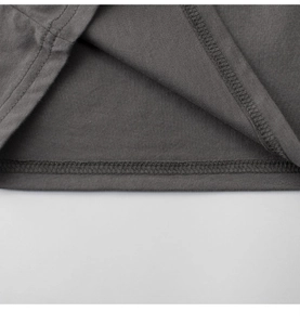 Close-up of double-needle stitching on the hem of a dark grey cotton kids t-shirt