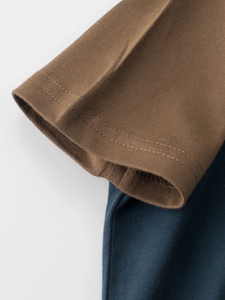 Close-up of cotton boys' T-shirt sleeve with detailed double stitching in brown and navy